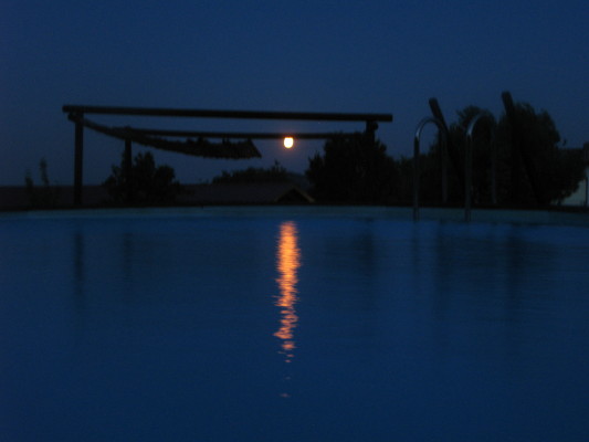 La luna piena si riflette sull'acqua della piscina